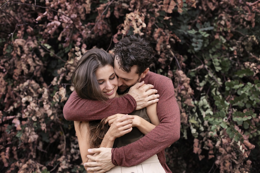 pareja feliz se abraza en un jardín