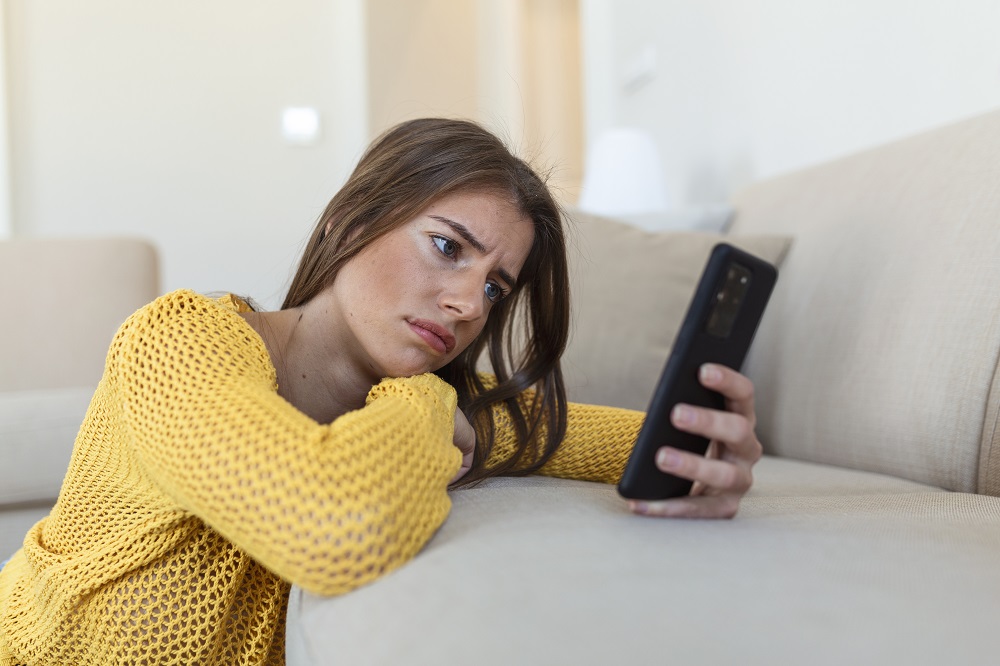 Mujer angustiada mira celular
